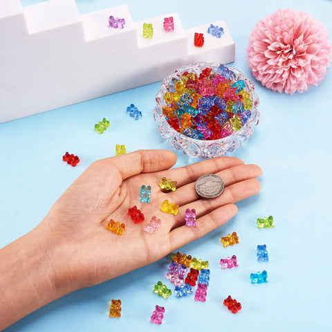 Hand holding multicolor 400Pcs Gummy Bear Acrylic Beads Transparent 12x8mm for jewelry making, with coin for size reference