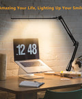 Eye-Care Swing Arm Desk Lamp With No-Fuss Clamp For Home Office illuminating a desk with laptop and books