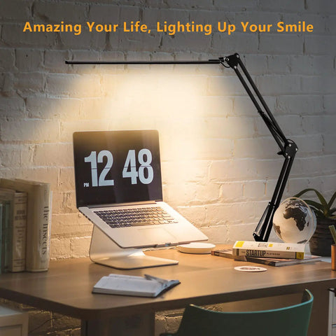 Eye-Care Swing Arm Desk Lamp With No-Fuss Clamp For Home Office illuminating a desk with laptop and books