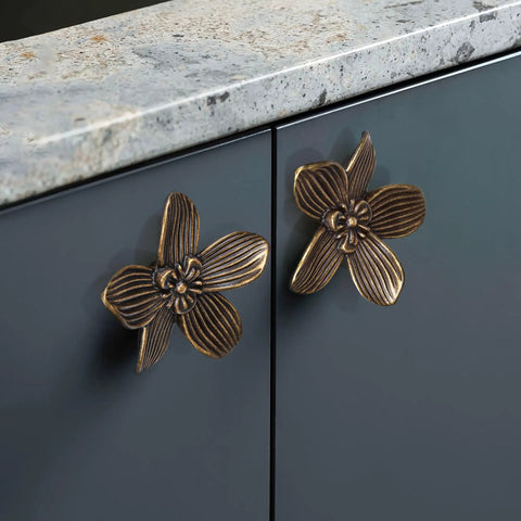 Four Pack Two Point Four Inch Antique Brass Flower Cabinet Knobs With Vintage Floral Drawer Pulls installed on grey cabinet