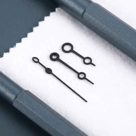 Black metal watch hands set for NH35 364R 7S movements on cloth, showing detailed horology repair accessories