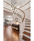 Modern 16 Light Ceiling Pendant With Heavy Duty Black Metal Frame And Crisp Crystal Drops For A Straight Up Room Makeover And A Seriously Lit Ambient Vibe hanging over a curved staircase.