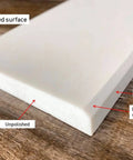 Solid White Engineered Marble Doorway Threshold Saddle, Polished Gloss Finish, 4 Inch By 30 Inch, edge details on wooden surface