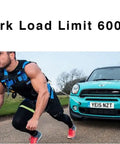 Man in harness pulling car, labeled 'Work Load Limit 600 LB', demonstrating strength training exercise on road.
