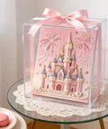 Dope 3D Castle Beaded Art Kit With Pearl Painting displayed in a clear box with a pink ribbon, on a table with macarons.