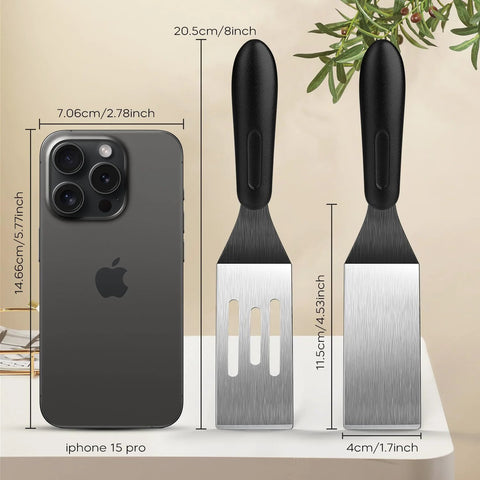 Front view of two mini metal spatulas with black handles; one slotted blade and one solid blade for serving and turning.