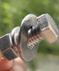 Close-up of a stainless steel hex-head bolt with washer and nut, fully threaded, 3/8-16 x 1-1/4.