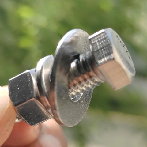 Close-up of a stainless steel hex-head bolt with washer and nut, fully threaded, 3/8-16 x 1-1/4.