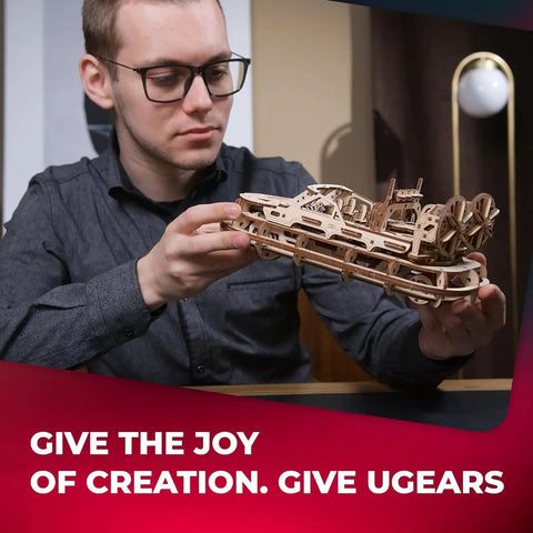 Rescue Hovercraft Wood Model Kit For Builders 1 24 Scale With Windup Motor And Intricate Twin Prop Design Perfect For Dope Hands On Crafting And Collectible Hobbyists, man holding assembled wooden hovercraft model