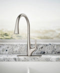 Top Shelf Pull Down Kitchen Sink Faucet With Smooth Glide Retractable Hose And Dual Function Sweep Sprayhead Built Tough For Lightning Fast Cleanup In Classic Vibrant Stainless Finish on a granite countertop.