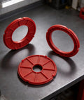 Heavy Duty Insertion Ring Set Crafted For RA1171 RA1180 RA1181 Router Tables showing three red plastic rings on a workbench.