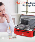 Red medicine organizer bag with double layer design for home and travel, open to show compartments, on a table.