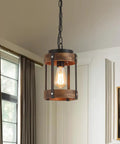 Rustic Farmhouse Pendant Lights Two Pack In Solid Oak And Matte Black Metal Cages With Long Adjustable Chains hanging from ceiling.