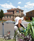 Keep Little Kids And Pets From Sneaking Out With This Hecka Secure Vertical Pull Safety Gate Latch Featuring Strong Magnetic Lock And Loud Alarm For Backyard Fence Gates In Classic Black, installed with a woman gardening.