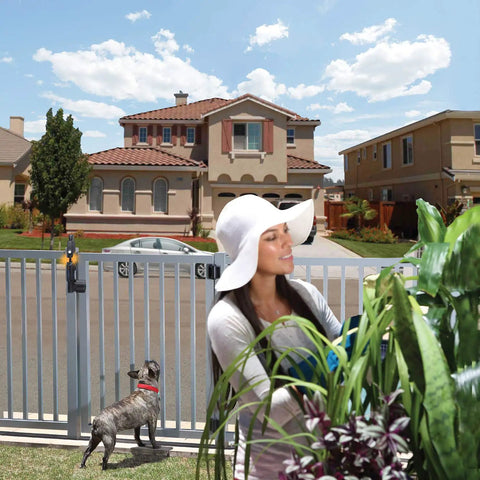 Keep Little Kids And Pets From Sneaking Out With This Hecka Secure Vertical Pull Safety Gate Latch Featuring Strong Magnetic Lock And Loud Alarm For Backyard Fence Gates In Classic Black, installed with a woman gardening.