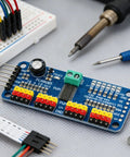 Close-up of 2-Pack PCA9685 16-Channel PWM Servo Driver Module for Arduino Robots, I2C Control, surrounded by tools and wires.