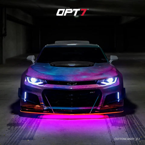 Sports car with Aura Aluminum Car Underglow Lights with Remote, displaying vibrant RGB glow, in a dark parking garage.