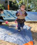 Child standing on Pocket Picnic Blanket For Grab And Go Outdoor Fun That Folds Small And Lightweight Sandproof 55 By 60 Inch Beach Mat