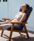 Woman relaxing on chair with Indoor Outdoor Rocking Chair Cushion Navy Blue Waterproof High Back Pad For Lounger And Recliner Patio Chair Pad