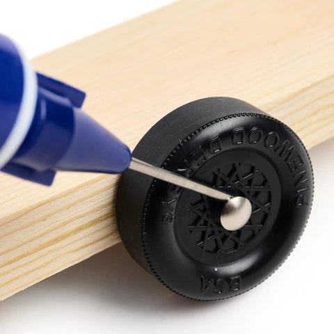 Dry Graphite With Moly Lubricant For Pine Derby Car Axles Pro Grade Easy Apply Needle Tip Applicator in use on wheel.
