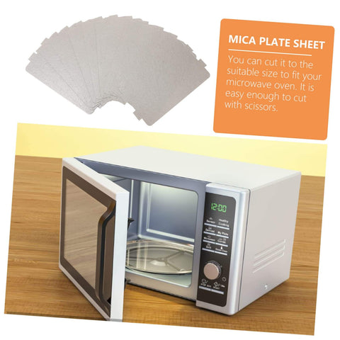 Microwave Waveguide Mica Sheets 12 Pack Heat Resistant Insulation Pads and Replacement Plate with a microwave on a wooden table.