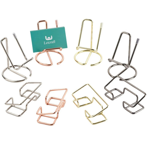 Assorted metal desk card holders in different finishes, including a gold holder displaying a card, perfect for office use.