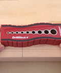 Drill Block Plus Handheld Drilling Guide with nine imperial drill bit sizes, held over wood, showing v groove and size markings.