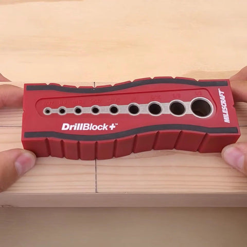 Drill Block Plus Handheld Drilling Guide with nine imperial drill bit sizes, held over wood, showing v groove and size markings.