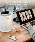 Compact air purifier on desk beside a laptop during a video call in a cozy setting.