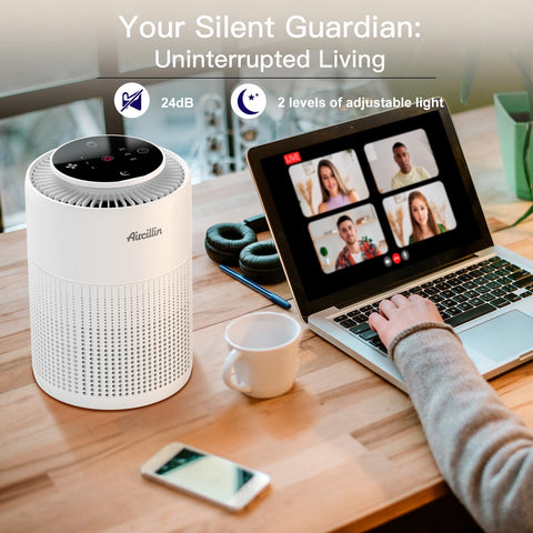 Compact air purifier on desk beside a laptop during a video call in a cozy setting.