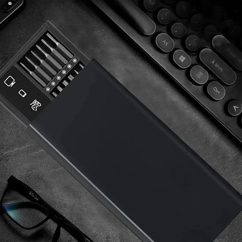 50 In 1 Magnetic Precision Screwdriver Set With Case on a desk, next to a keyboard and glasses, showing screwdriver bits and case.
