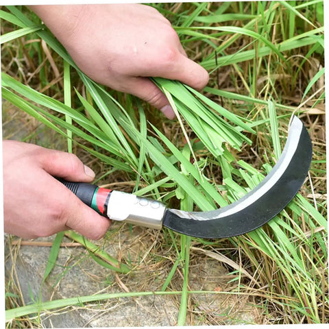 Close-up of a hand using a manganese steel sickle with ergonomic handle for cutting grass, part of a durable workhorse yard tool.
