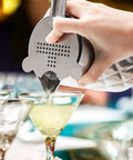 Pouring a cocktail using Kickback Ready 18 Oz Stainless Steel Cocktail Mixing Glass With A Weighted Base And Double Wall Construction.
