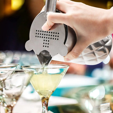 Pouring a cocktail using Kickback Ready 18 Oz Stainless Steel Cocktail Mixing Glass With A Weighted Base And Double Wall Construction.