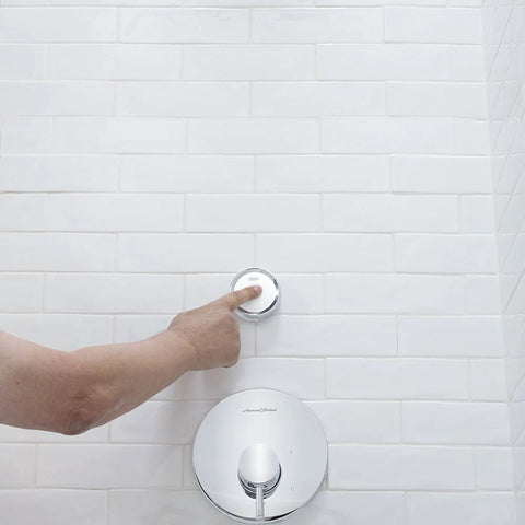 Hand using wall remote control for Spectra Plus ETouch 4 Function Shower Head With Wall Remote, Easy Touch Pattern Switch in bathroom.