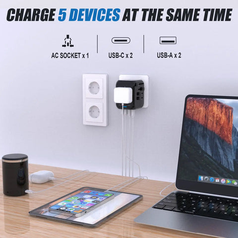 All In One Travel Adapter With 2 USB C And 2 USB A Ports for worldwide use plugged into wall charging multiple devices