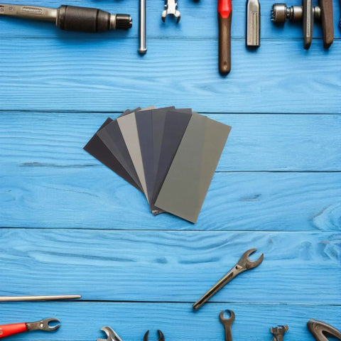56pc Wet And Dry Sanding Kit With Multi Grit Sheets 400 To 5000 Grit Carborundum Paper For Metal And Plastic on blue table with tools