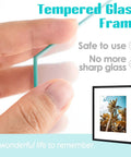 Hand holding HD glass of 16x20 Picture Frame With Mat For 11x14 Photo Black 2 Pack HD Glass Wide Molding Removable Mat Preinstalled Wall Mounting Hardware Modern Gallery Style For Prints Posters And Photos, with palm tree poster inside.