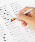 Hand holding one of the 72 Piece Golf Pencils With Erasers, Short Hexagon Pocket Pencils Pre Sharpened Number 2 HB on a test sheet.