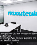 Conference room with "mxuteuk" logo on wall, featuring table, chairs, and phone for professional meetings.