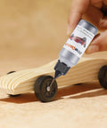 Applying graphite lubricant from Derby Car Pinewood Weights Kit With 3 Oz Stick On Flexible Weights And Half Ounce Graphite Lubricant For Fast Smooth Wheels And Killer Speed Tuning Easy To Cut With Scissors For Custom Weight Distribution And Quick Setup to pinewood derby car wheels