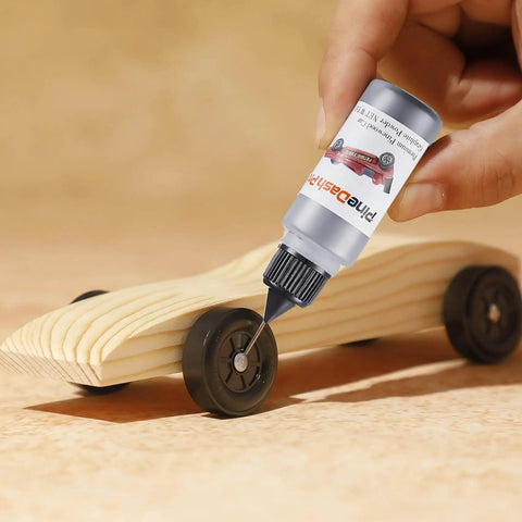 Applying graphite lubricant from Derby Car Pinewood Weights Kit With 3 Oz Stick On Flexible Weights And Half Ounce Graphite Lubricant For Fast Smooth Wheels And Killer Speed Tuning Easy To Cut With Scissors For Custom Weight Distribution And Quick Setup to pinewood derby car wheels