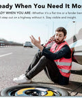 Rock This Neon Pink Three Pack Reflective Safety Vest For Men And Women Featuring Bold Two Inch Strips For Genuine High Visibility Coverage On Active Job Sites And Nighttime Outdoor Tasks Stay Safe Out There Straight Up Every Single Day worn by a man sitting on the roadside with a flat tire.