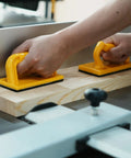 Hands using Heavy Duty Push Block And Push Stick Set For Table Saws Router Tables Band Saws on wood for safer cutting.