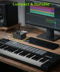 Compact dual channel stereo mixer for computer and console setup with gold-plated RCA jacks next to a keyboard and monitor