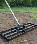 Beast Heavy Duty Lawn Leveling Rake with 30 Inch by 10 Inch head, stainless steel handle, in use on soil