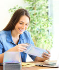 Woman using Dope Rainbow Holographic Bubble Mailers 6 By 9.5 Inch for packaging at desk with laptop, focus keyword in context.