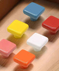 Assorted colored ceramic cabinet knobs displayed, similar to Glossy Ceramic Square Cabinet Knobs 1.25 Inch Green Six Pack Kid Friendly.