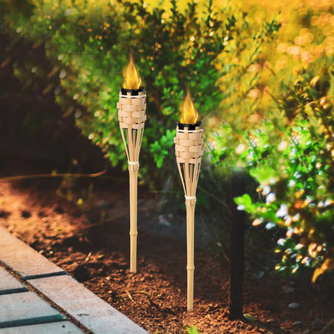 Natural Bamboo Tiki Torch Outdoor Set 2 Pack With Decorative Woven Design For Backyard Vibes And Garden Lighting Outdoor Parties Weddings Festivals Eco Friendly Oil Lamps installed in garden