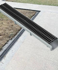 Durable Trench Drain Kit For Yard, Lawn, Driveway And Sidewalk With No Fuss Install, Heavy Duty SMC Resin Drainage System Including Drain Cover And End Cap For Fast, Efficient Water Removal And Long Lasting Performance displayed in a yard setting
